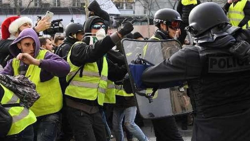 &quot;Chalecos&quot; y policías se enfrentan en los Campos Elíseos parisinos. // AFP