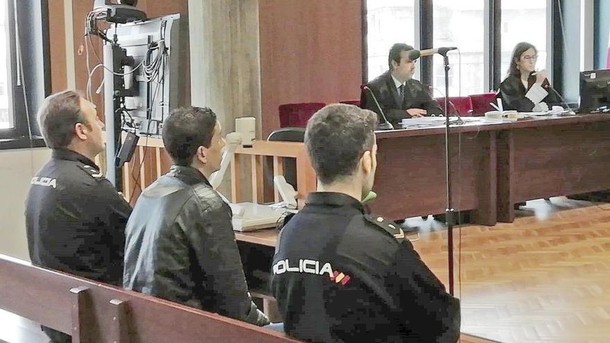 El acusado, escoltado por la Policía, ayer en el la Audiencia. // FdV