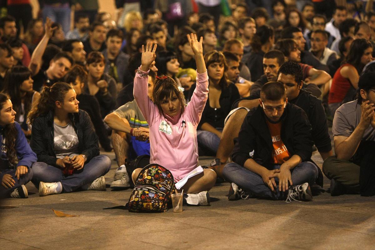 Una manifestante vota en la asamblea de los indignados de Zaragoza, alzando las manos.