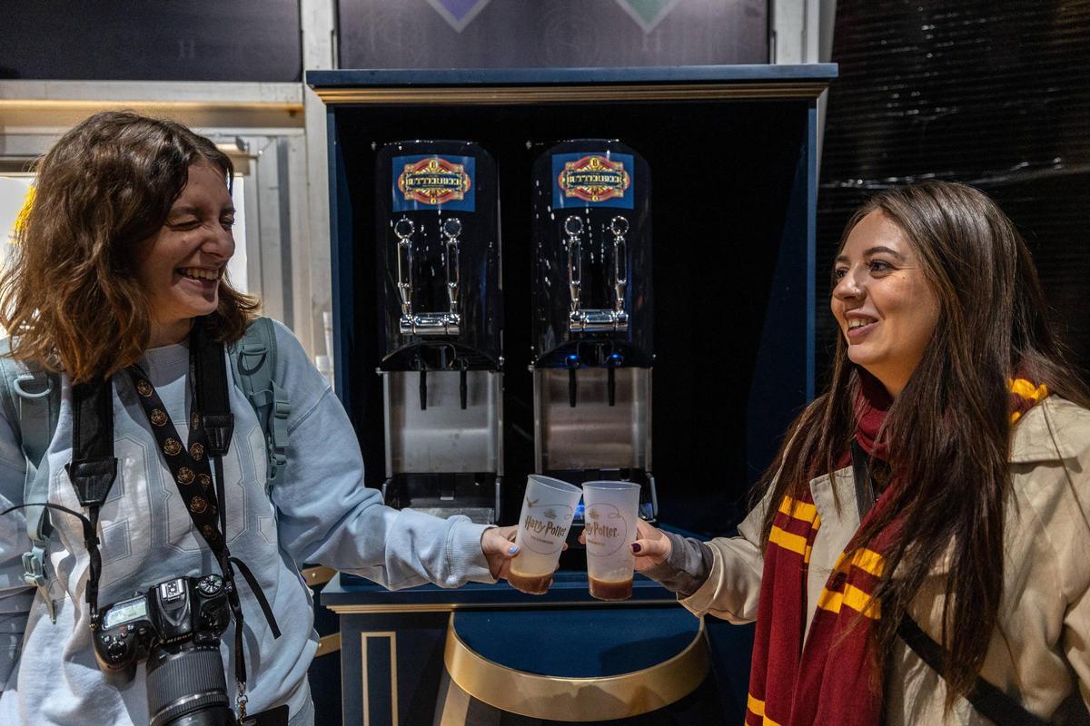 Dos chicas brindan con la 'cerveza de mantequilla' de la saga, novedad en esta visita de 'Harry Potter: La Exposición' en Barcelona.