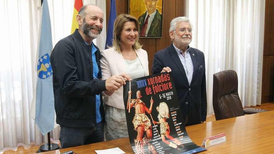 Julió Fernández, Olga Mojón y Rosendo Luis Fernández con el cartel anunciador. // Iñaki Osorio