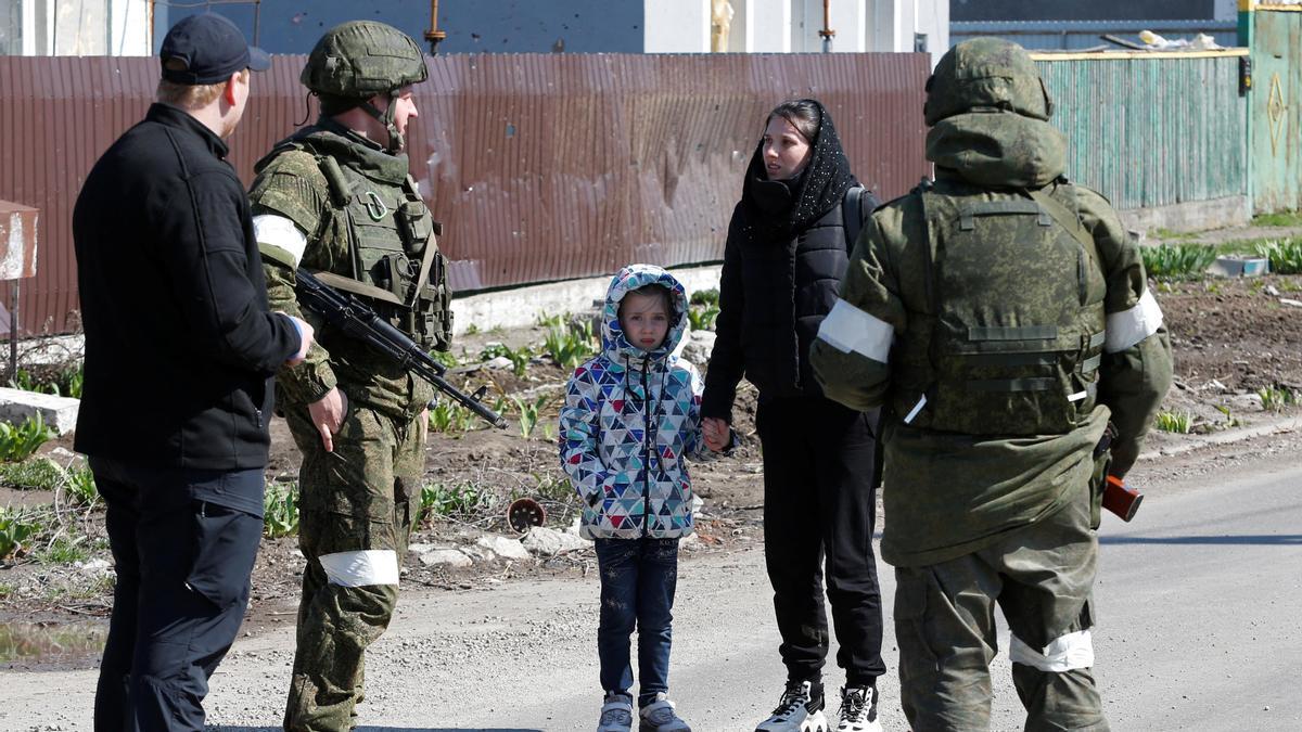 Una mujer con un niño habla con miembros del servicio de las tropas prorrusas.