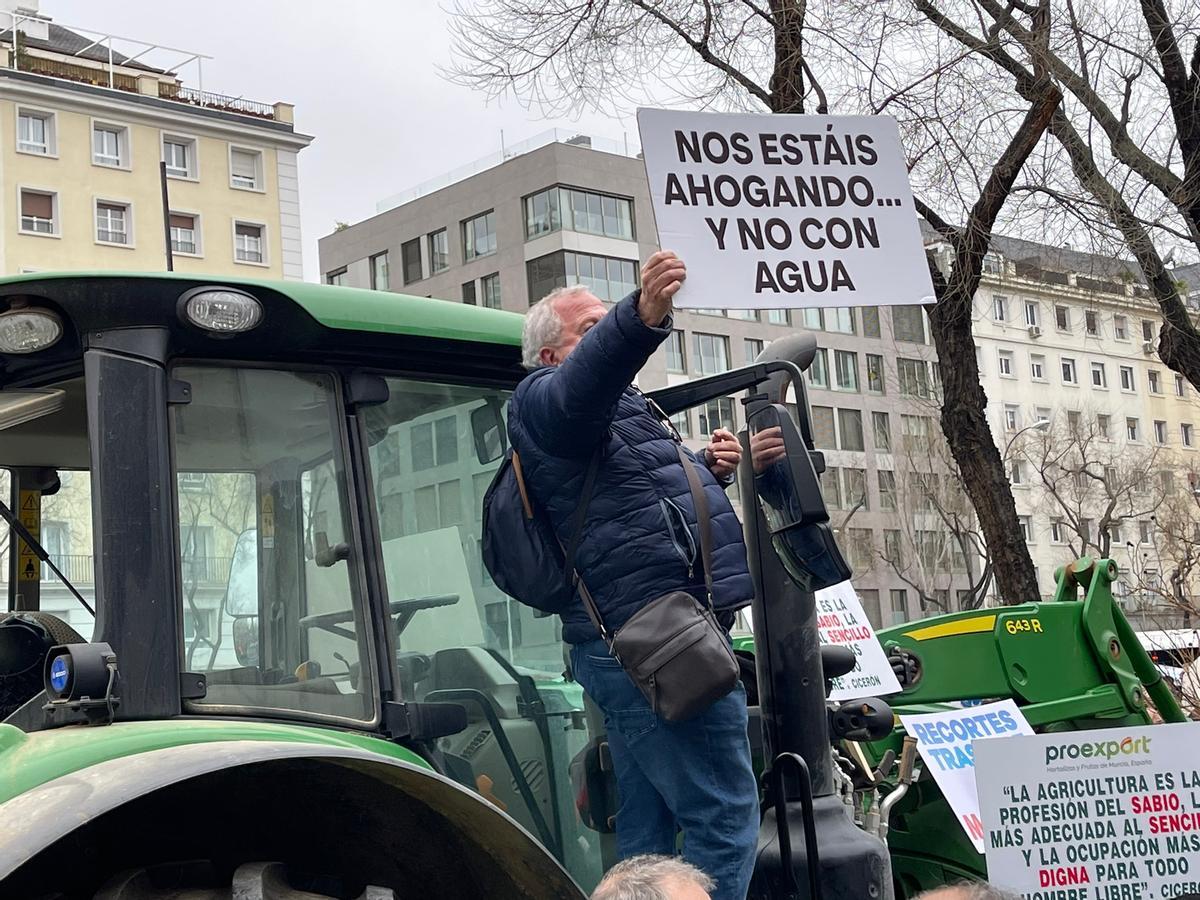 Un regantes muestra un cartel denuciando la situación.