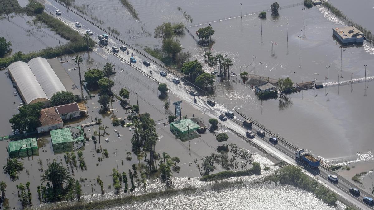 Vehículos atravesando la carretera N-332 inundada por la DANA de 2019 y que ejerció de efecto barrera para la evacuación de los azarbes desbordados de la huerta