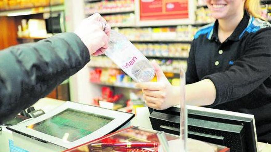 Un cliente devuelve unabotella de plástico deagua mineral en un tienda. | RETORNA