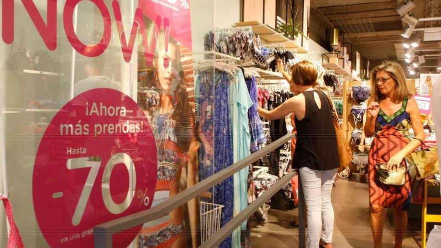 Dos mujeres observan las prendas ofertadas en rebajas