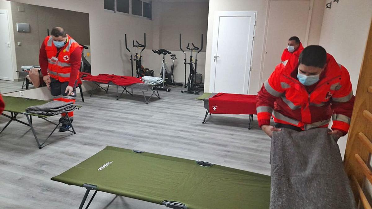 Voluntarios de Cruz Roja preparan las camas en uno de los albergues habilitados. | LEVANTE-EMV