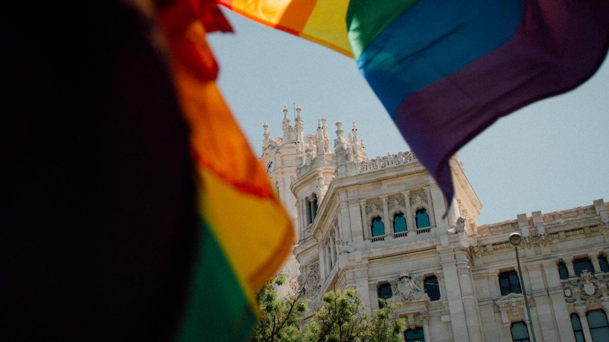 Banderas del Orgullo ondean en un quiosco de la plaza de Cibeles, frente al Ayuntamiento de Madrid.