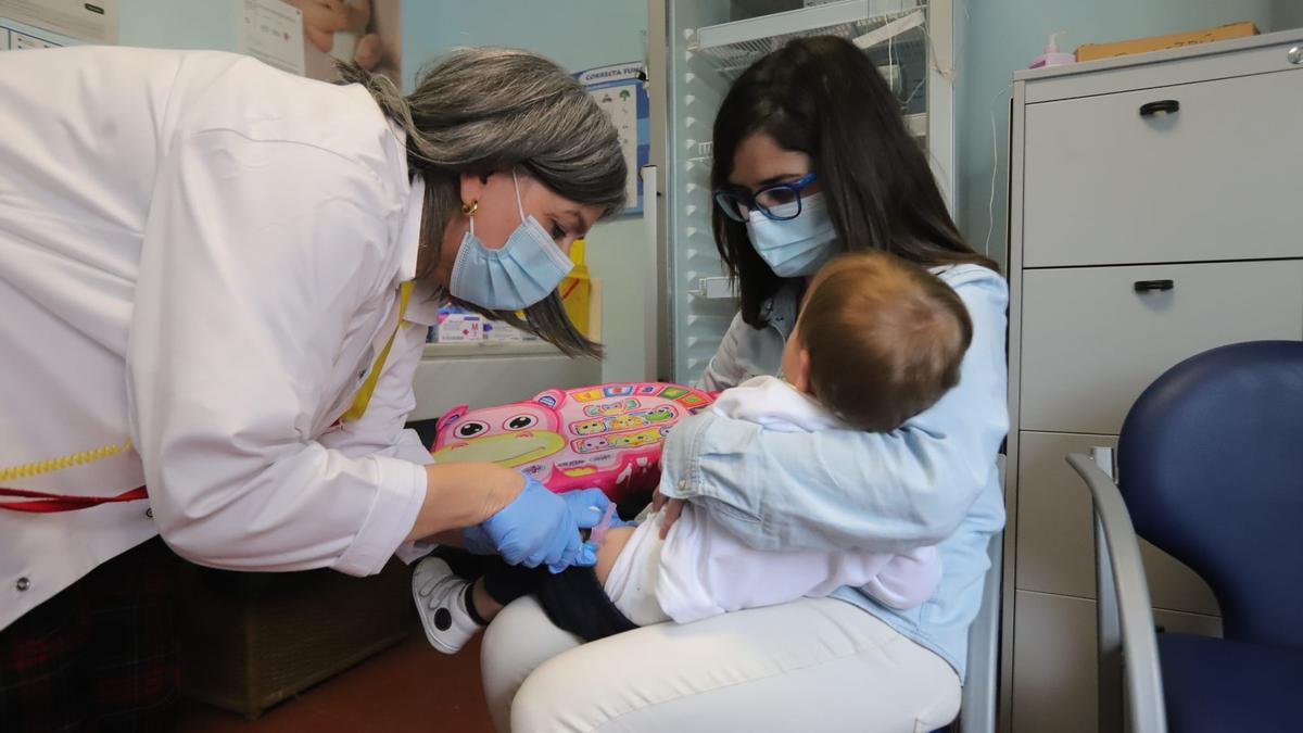 Un menor se vacuna frente a la gripe en el centro de salud Poniente.