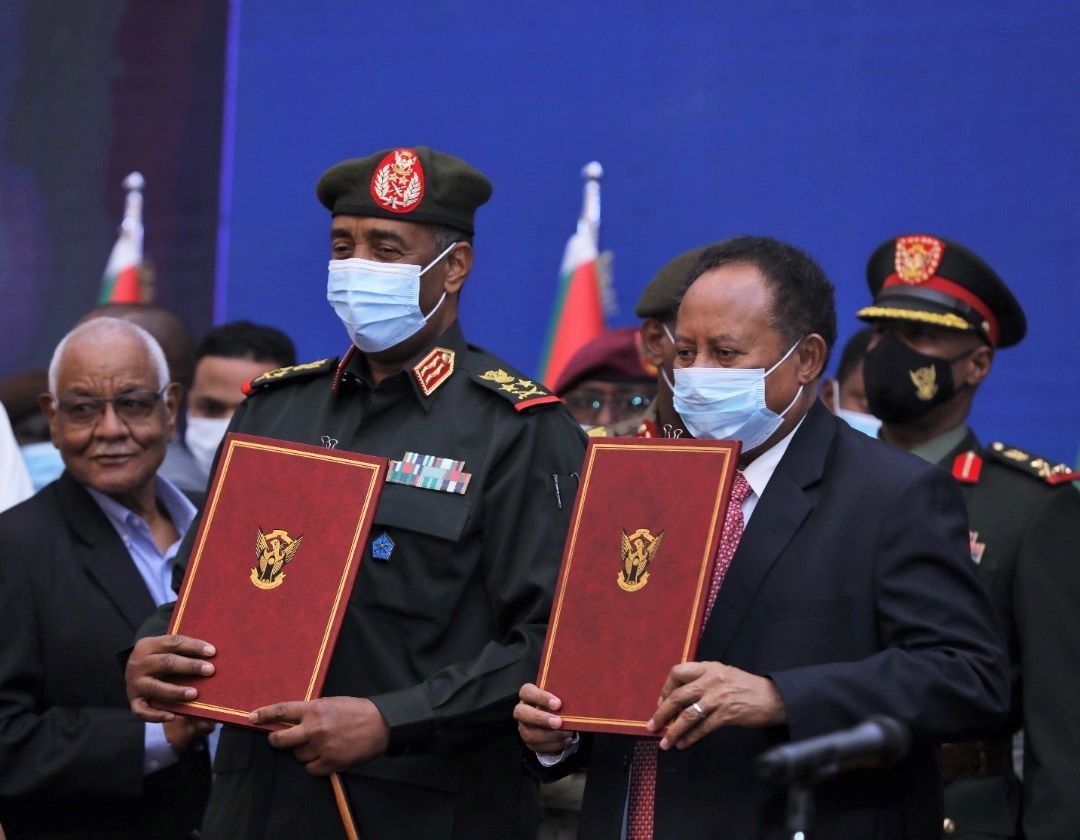 El primer ministro de Sudán, Abdalla Hamdok (derecha) y el teniente general del Ejército sudanés, anuncian un acuerdo que restituye en el poder a Hamdok, un mes después del golpe de Estado, en una imagen difundida por el Gobierno.
