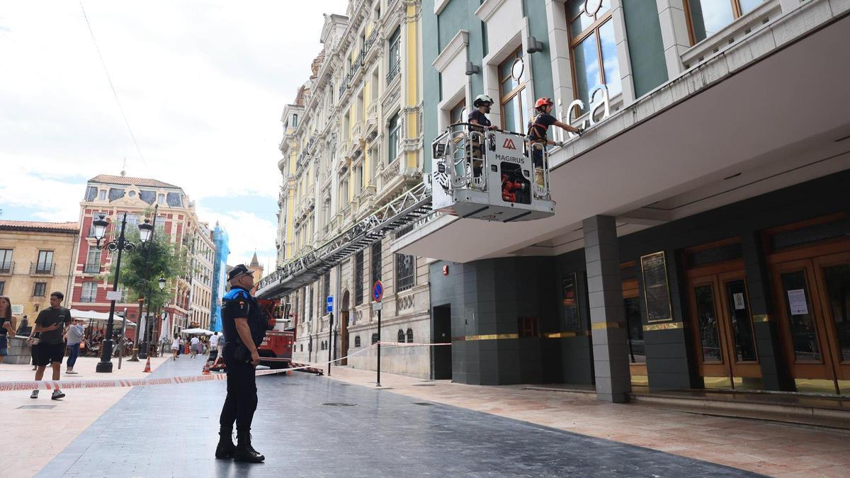 Los servicios de emergencia actúan en el lugar del suceso, mientras el embellecedor caído permanece apartado frente a las puertas del teatro