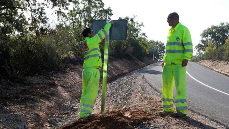 Dos trabajadores colocan las señales en el trazado que une Fornillos de Fermoselle con La Venta.