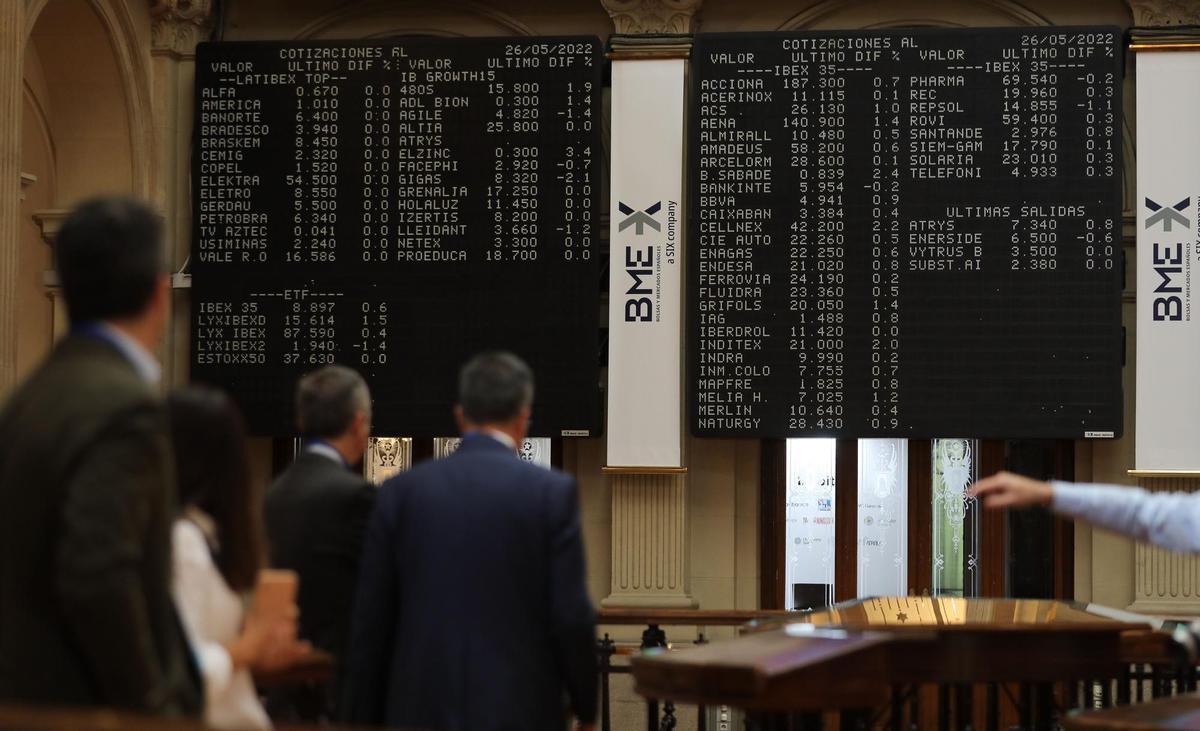 Archivo - Varias personas frente a los paneles de valores del IBEX 35 en el Palacio de la Bolsa de Madrid, a 26 de mayo de 2022, en Madrid (España). Las empresas del Ibex 35 generaron, de forma agregada, un beneficio neto récord de 57.797 millones de euro