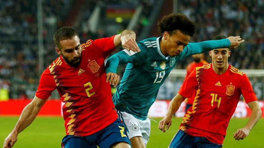 Lerey Sane conduce la pelota con la opsición de los españoles Dani Carvajal y Luis Vázquez. // Reuters