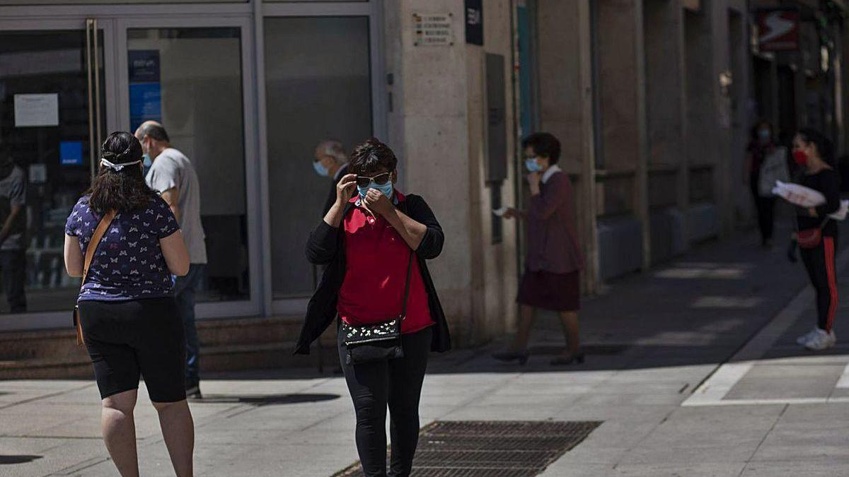 Ciudadanos aguardan para entrar en una entidad bancaria en Santa Clara.