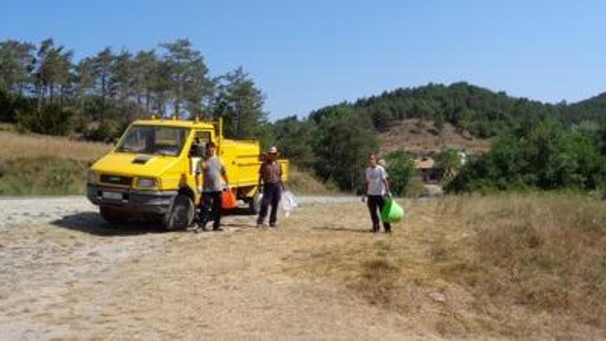 Operaris amb bosses amb deixalles recollides a l&#039;entorn de la riera.