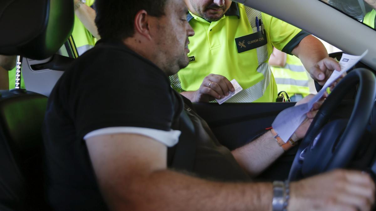 Un agente de la Agrupación de Tráfico de la Guardia Civil multa a un conductor en el primer día de la campaña que ha puesto en marcha la DGT para controlar los excesos de velocidad y concienciar sobre sus consecuencias, que se llevará a cabo en las carreteras españolas hasta el próximo 28 de agosto. EFE/Juan Carlos Hidalgo