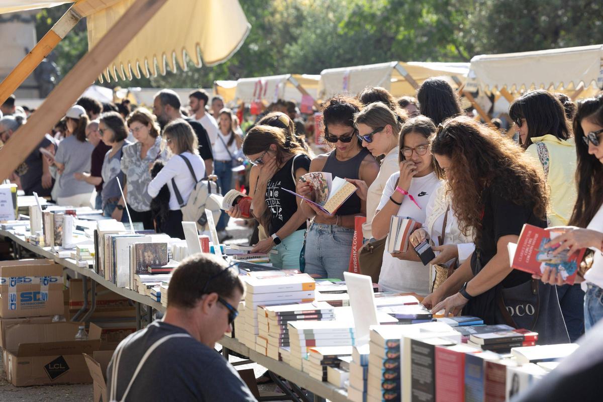 Joves inspeccionen llibres la diada de Sant Jordi a Vara de Rei.
