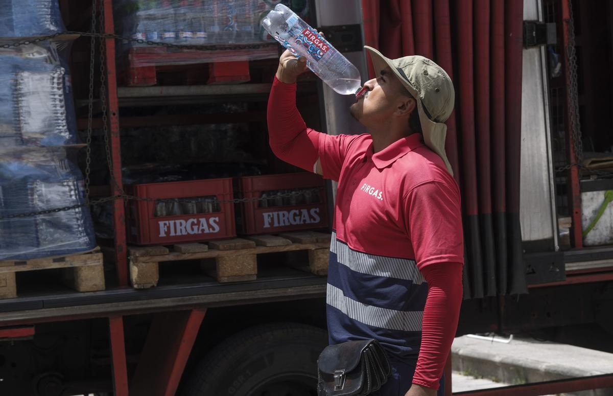 Santiago bebe agua en el municipio de Agüimes durante su jornada laboral.