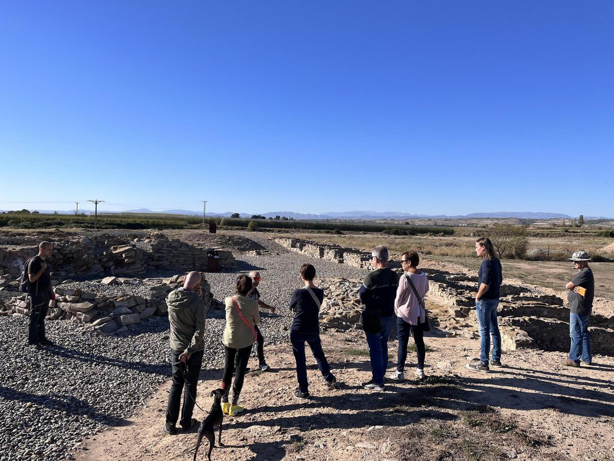 Un grup de visitantes explorando las ruinas íberas.