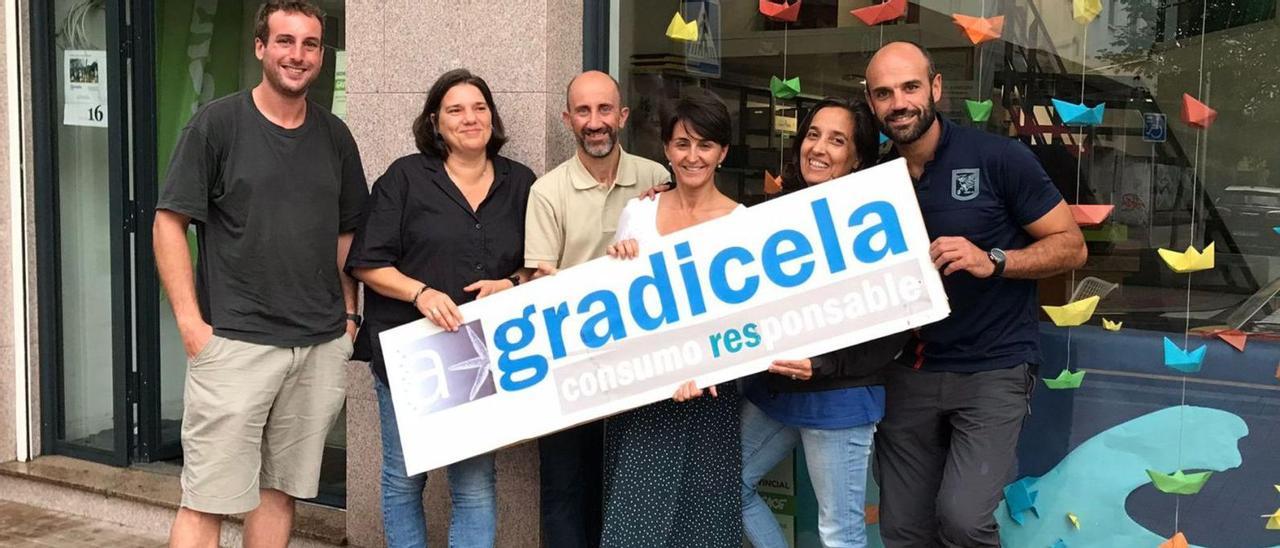 De izquierda a derecha: Borxa, Luz, Anxo, Geli, Pepa y David, sosteniendo el cartel de A Gradicela ante su local social.