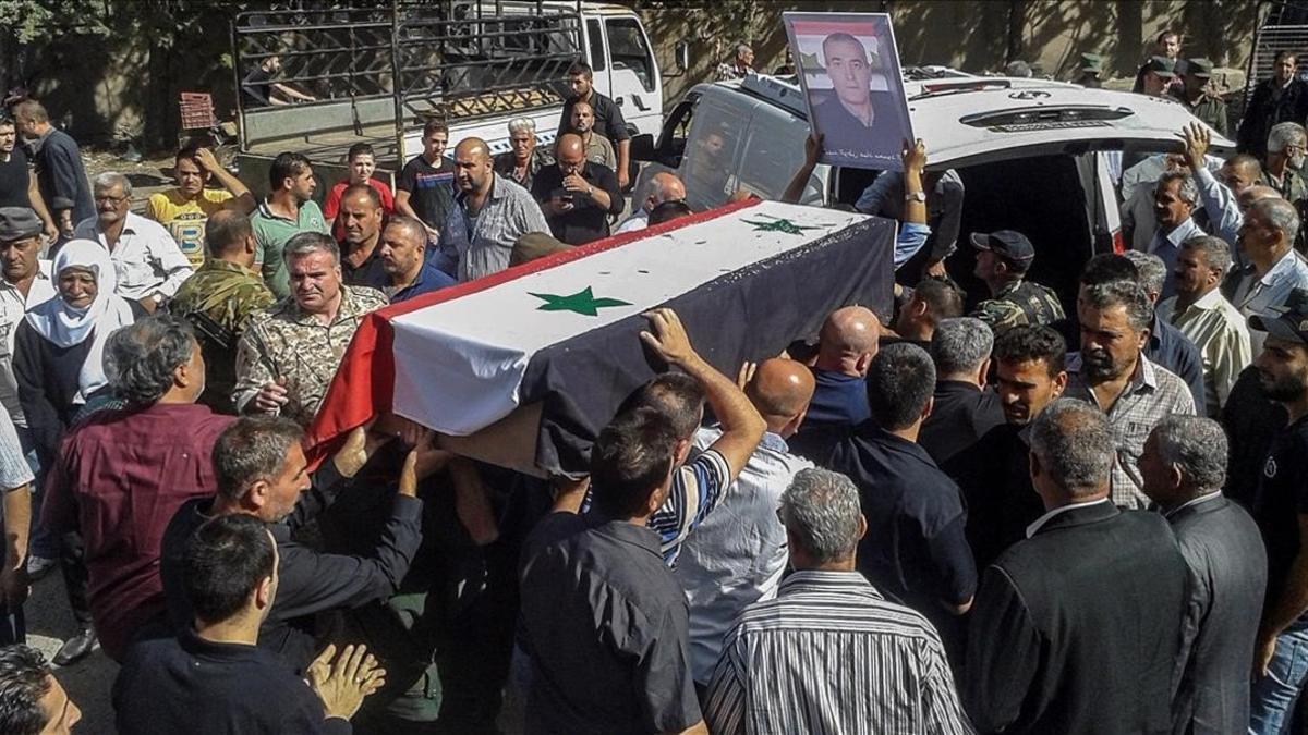 Ciudadanos sirios asisten a un funeral popular por las victimas del atentado del 25 de julio en la provincia de Al Sueida.