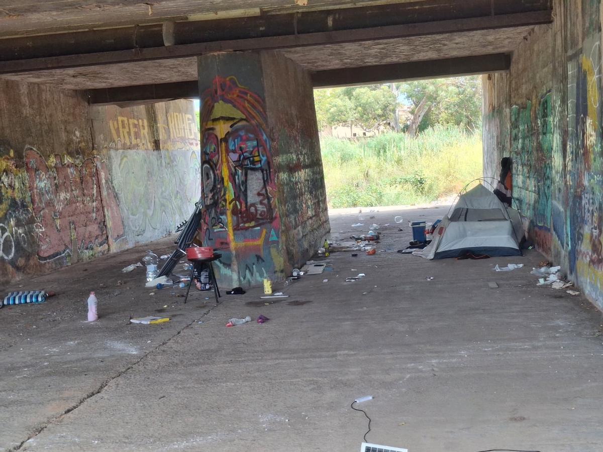 Un sintecho vive debajo del puente del río, cerca del "botellódromo" donde los jóvenes apuran la fiesta