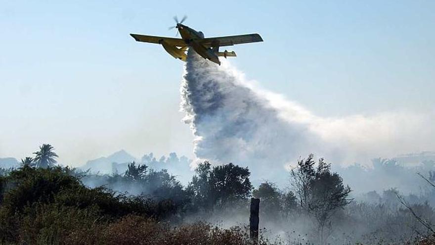 Un avión air tractor sobrevuela los terrenos arrasados por el incendio.