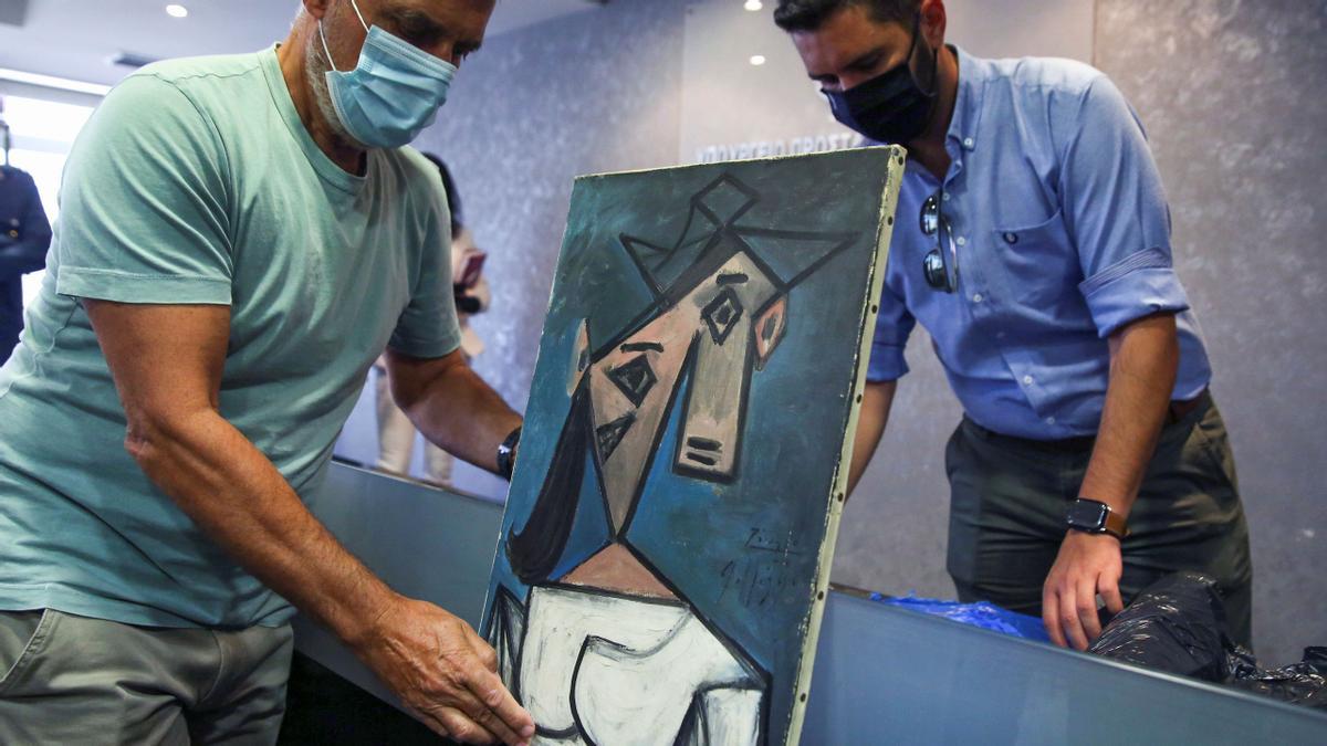 The paintings Woman’s Head by Pablo Picasso, and Mill by Piet Mondrian are displayed at the Ministry of Citizen Protection in Athens