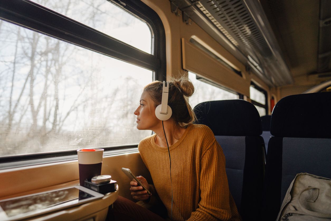 Mujer en un tren mirando por la ventana.