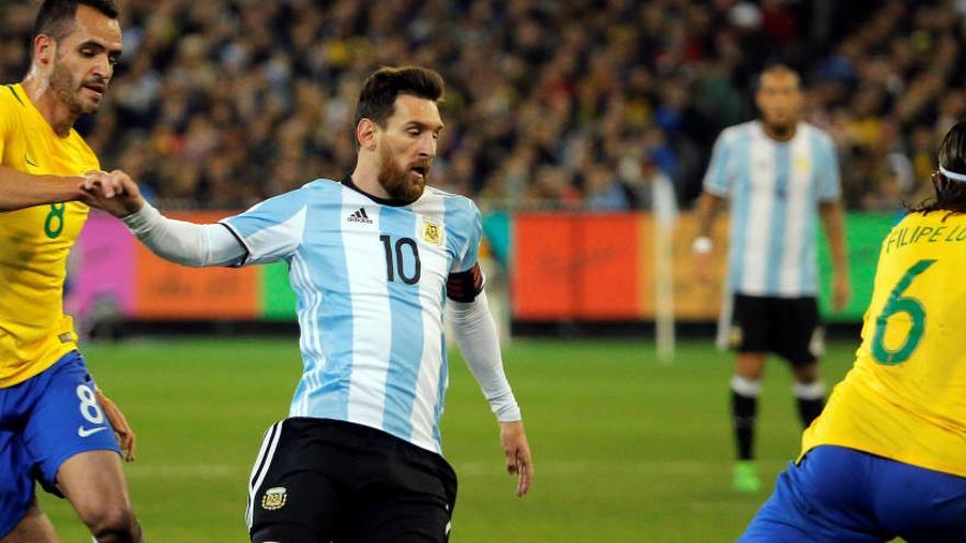 Leo Messi rodeado de contrarios de Brasil.