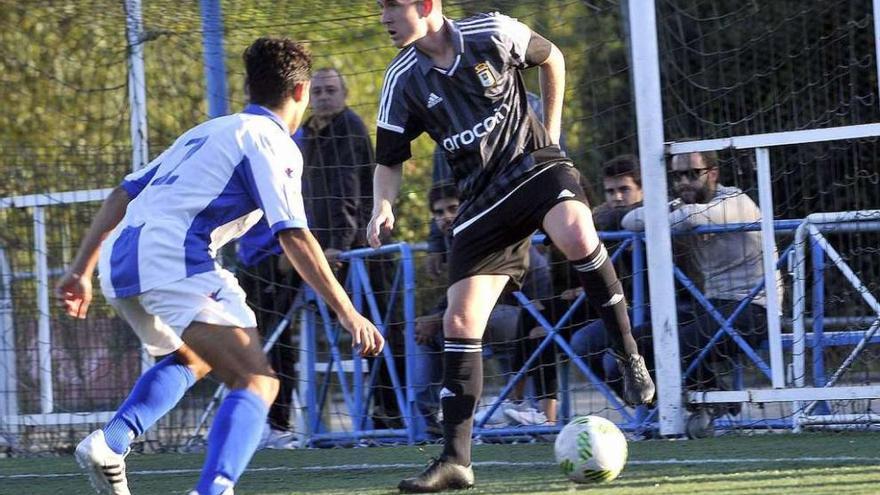 El jugador del Oviedo B Marcos, con el balón, presionado por un rival.