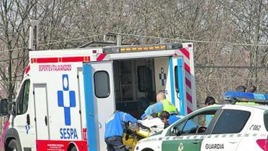 El personal sanitario introduce al joven en una camilla en la ambulancia.