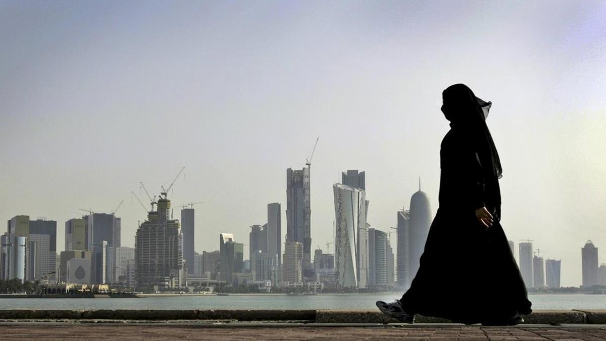 Una mujer qatarí con el skyline de Doha de fondo.