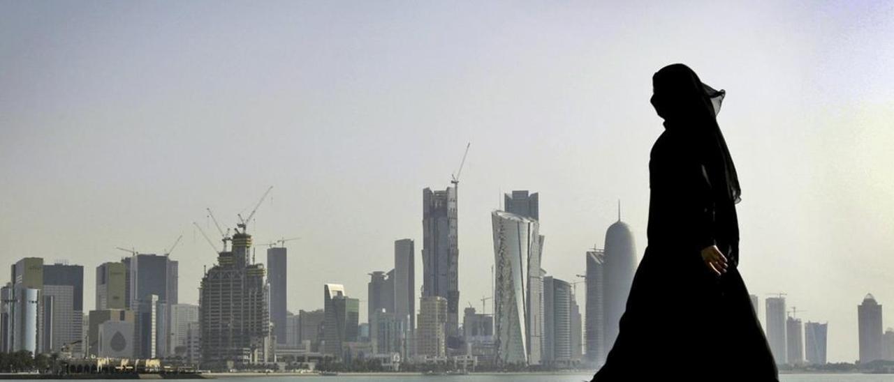 Una mujer qatarí con el skyline de Doha de fondo.