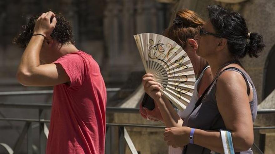 Una turista abanicándose.