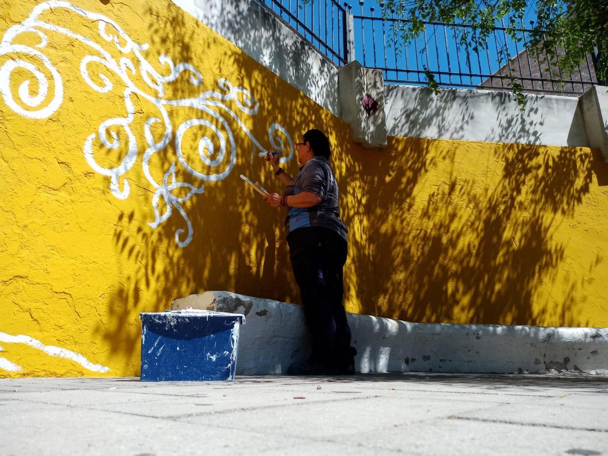 Una operaria pinta el mural que ahora ha sido vandalizado