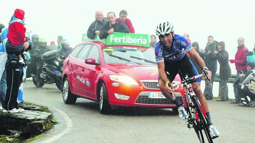 Carlos Barredo enfila la línea de meta seguido por el coche del director de carrera, en el que de pie siguen la etapa, de izquierda a derecha, el director general de Deportes del Principado, Misael Fernández Porrón; José Antonio Alonso, portavoz del Grupo Socialista en el Congreso, y Javier Guillén, director de la Vuelta.