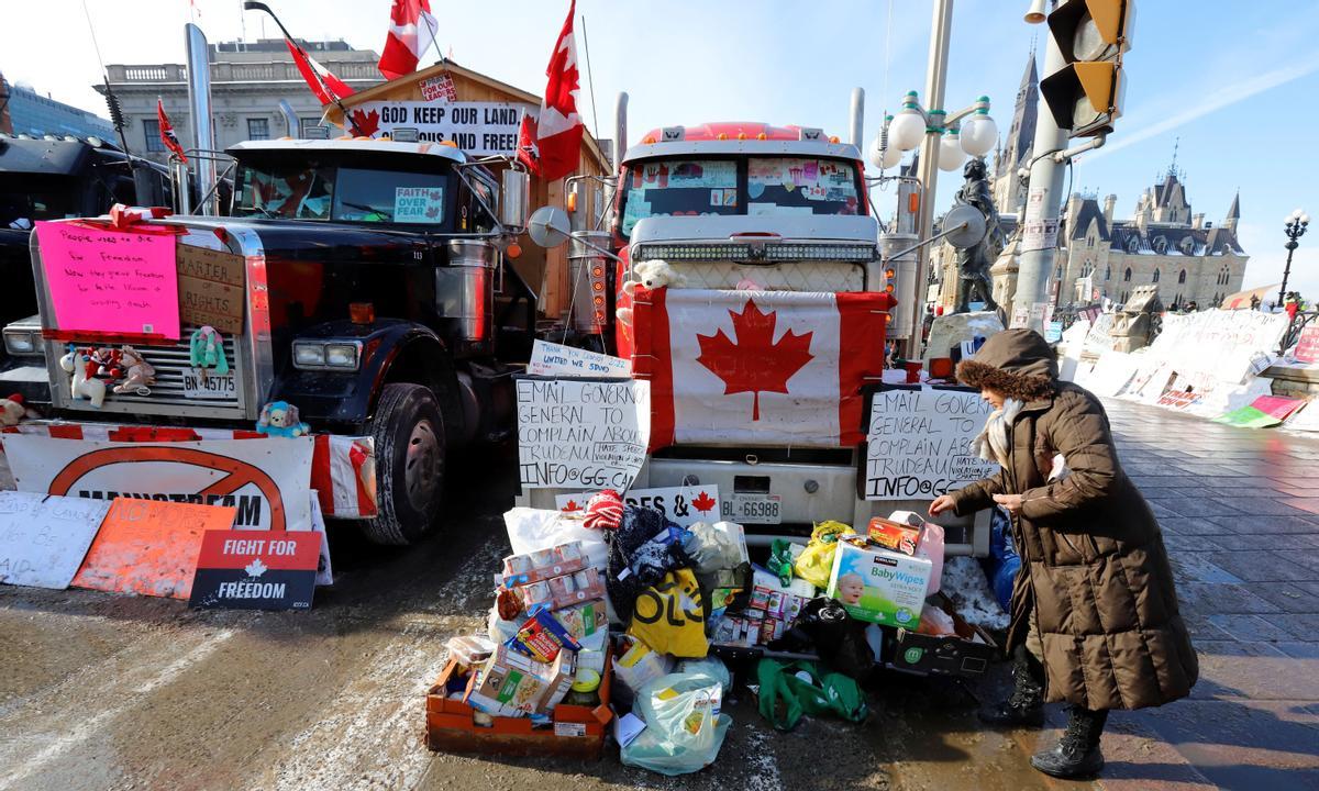 Una mujer pasa por delante de uno de los camiones que bloquean el centro de la ciudad de Ottawa, en Canadá.