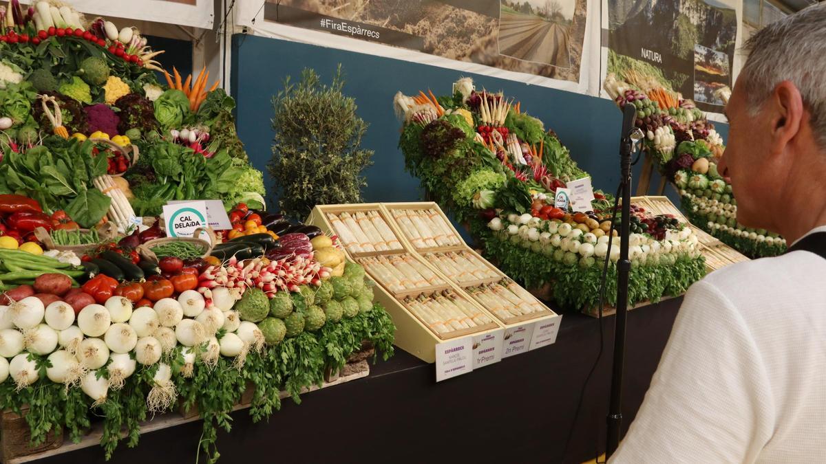 Un visitante de la Feria de Espárragos de Gavà observa las cestas de espárragos y otros productos del campo