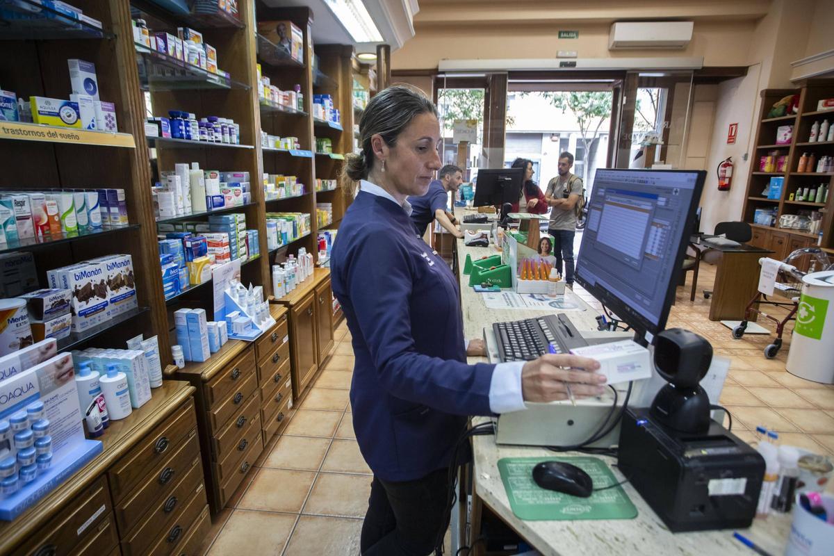 Elena Alcayde tratando de usar el sistema de receta electrónica en su farmacia de Patraix.