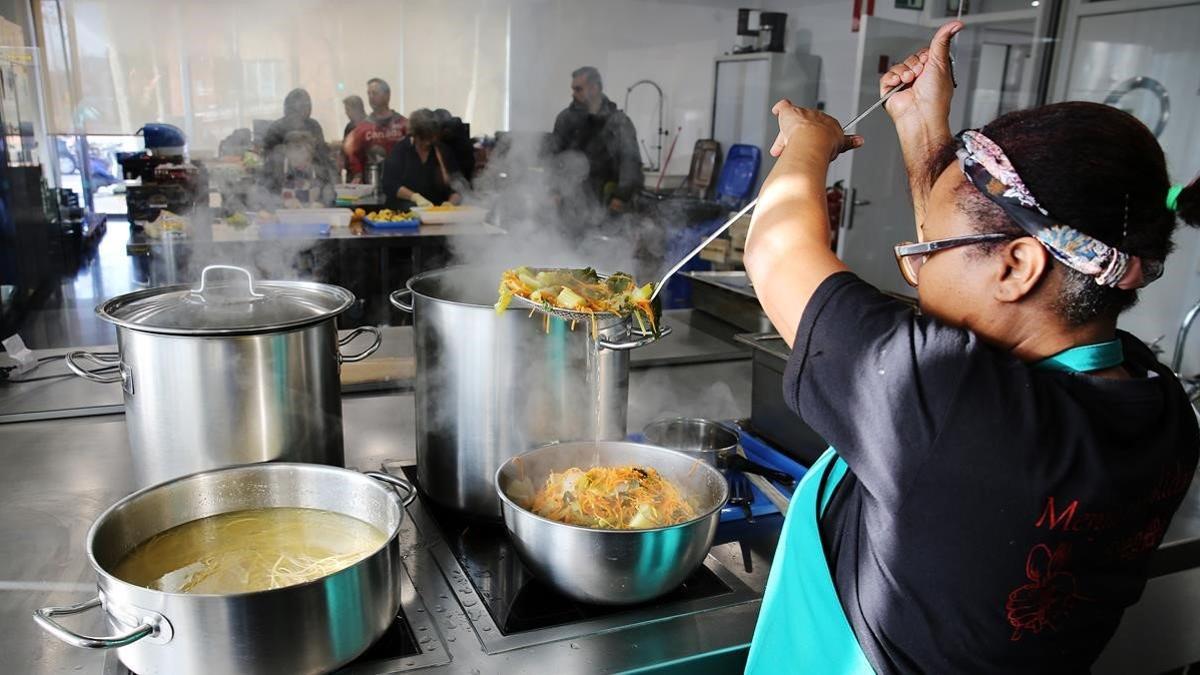 Los voluntarios del comedor social y solidario preparan el menú del día en los fogones de Ca l'Isidret