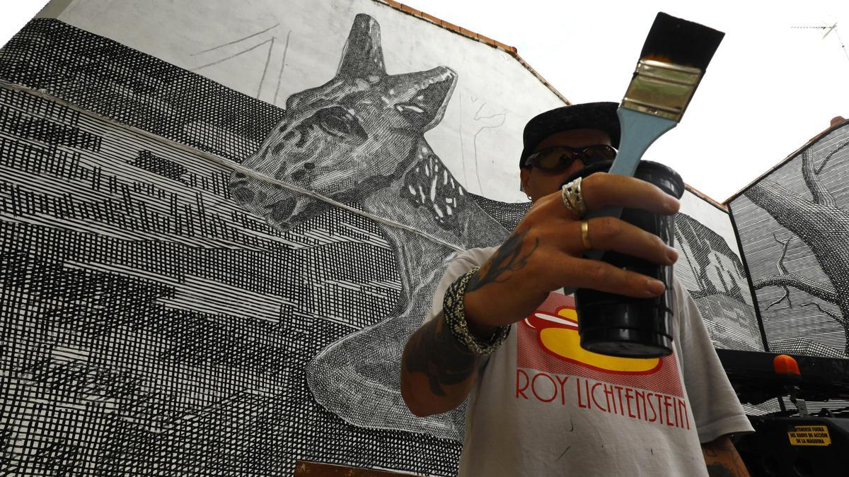 El artista argentino Tomás Facio posa este viernes con su mural en Torrero.