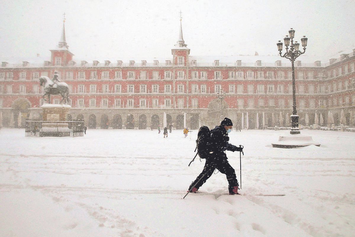 Un hombre pasea con sus esquís por la Plaza Mayor de Madrid durante la borrasca Filomena de 2021 /