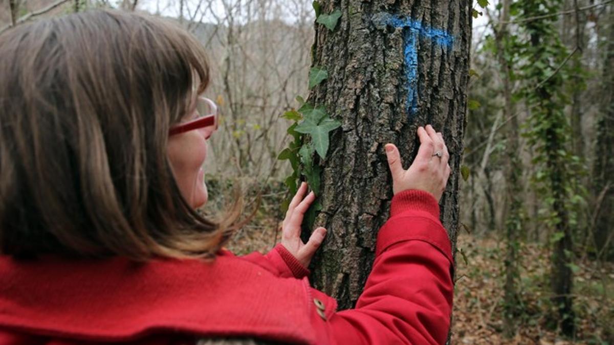 Una integrante de la plataforma Riudaurajunts señala una de las marcas aparecidas en el bosque.