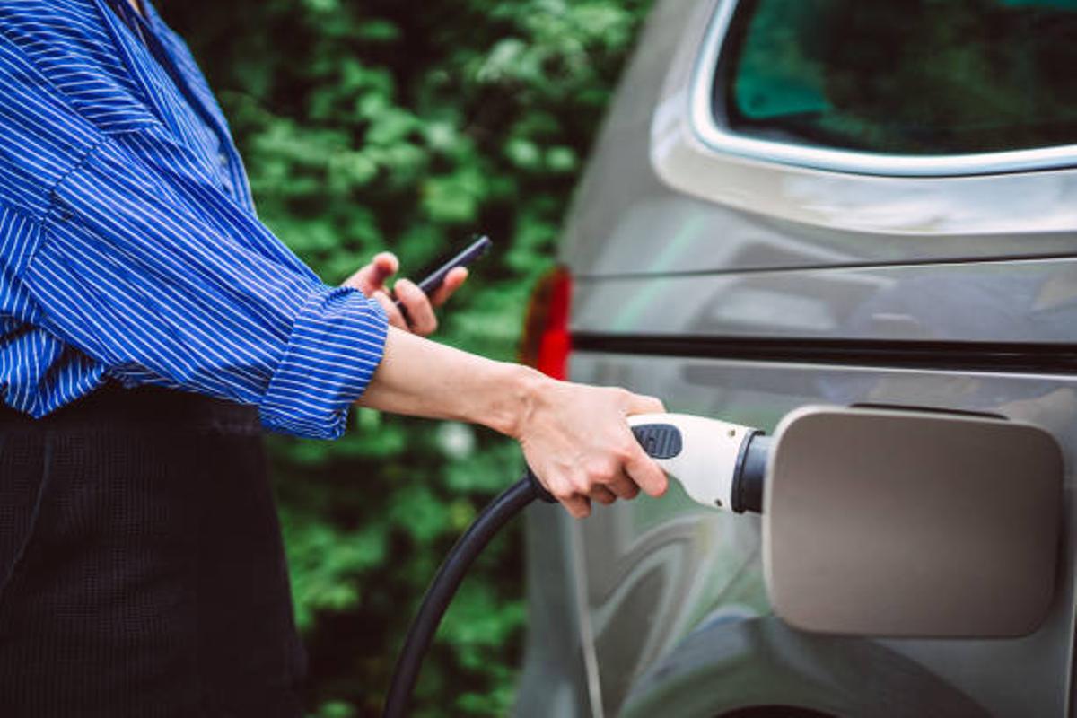 Mujer poniendo a cargar su coche eléctrico