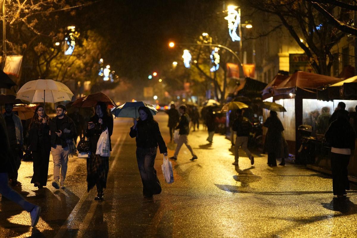 Jóvenes bajo la lluvia en el botellón de la calle Mandri