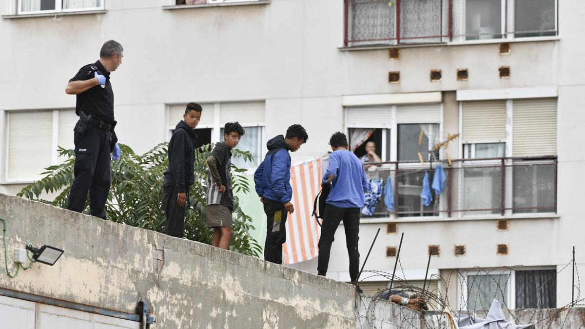 Un grupo de menores migrantes atrincherado en el tejado de una nave industrial en Ceuta.