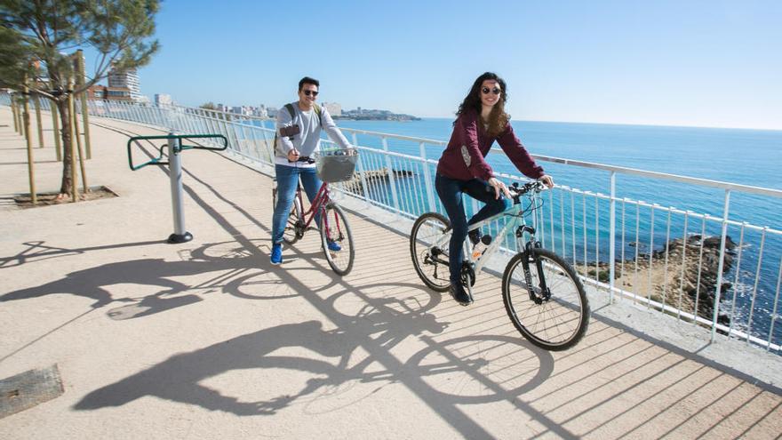 Dos ciclistas por el tramo del paseo litoral de la Cantera en Alicante