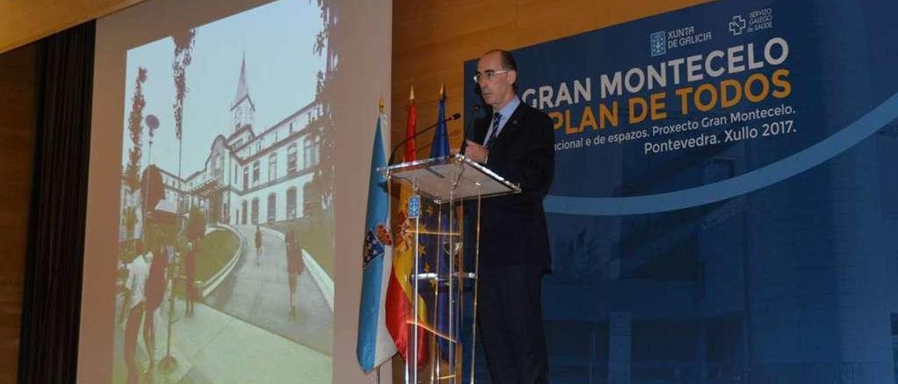 El conselleiro de Sanidade, durante la presentación, con una imagen de la fachada del Provincial. // G.S.